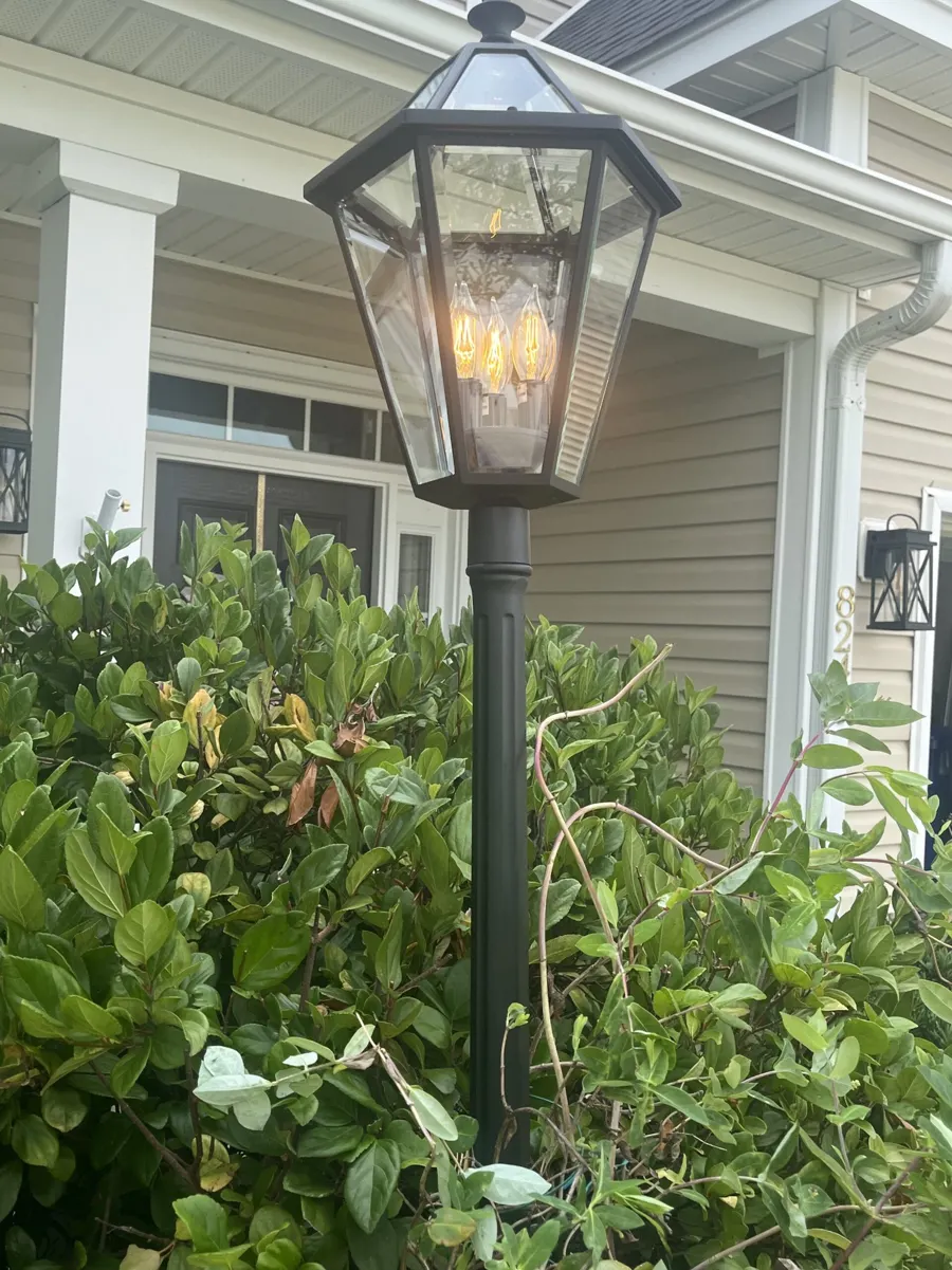 Gas-lamp-style post light installed in a landscaped front yard